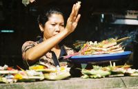 A woman makes an offering at an Ubud temple